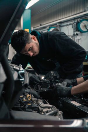 Técnico revisando sistema de rastreo en vehículo empresarial.