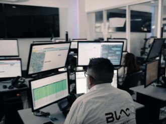 Operadores en centro de control con monitoreo 24/7 y rastreo satelital.