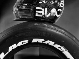 Casco de motociclista y neumático con logotipo de Blac en fondo negro.