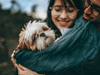 Pareja Feliz abrazando a tierno perro