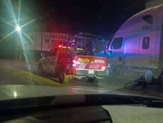 Vehículo de policía estatal monitoreando un tren en la noche.